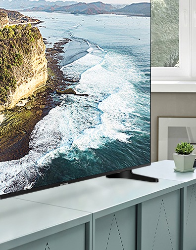 민트색 TV 수납장 위에 파도치는 영상이 보이는 TV 제품이 놓여져 있습니다.