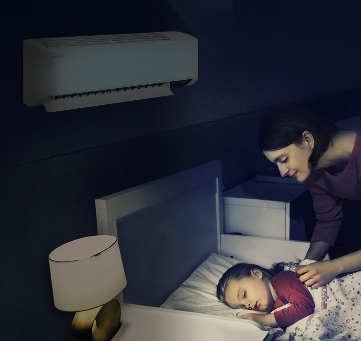 에어컨이 설치된 방에서 여성이 침대에 누워 자고 있는 아이를 바라보는 모습이 보입니다.