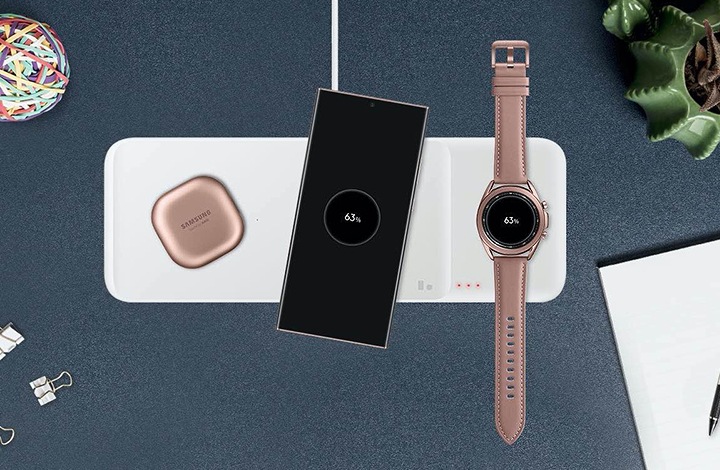 책상 위에 다양한 소품과 함께 무선 충전 트리오 제품이 놓여있습니다 그 위에 갤럭시 버즈 라이브, 갤럭시 노트20 Ultra 5G, 갤럭시 워치3 제품이 놓여져 충전되고있습니다.