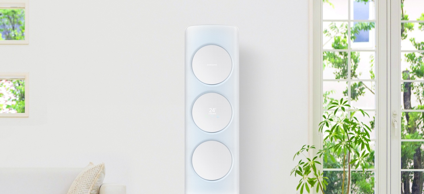 쾌적하고 밝은 거실에 놓인 Q9500 메탈 화이트 제품이 보이고 오른쪽으로 나뭇잎이 살짝 흔들리는 모습입니다.