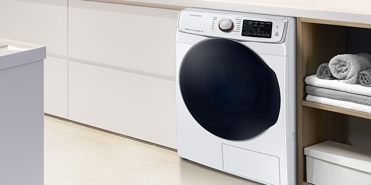 화이트 톤의 공간에 건조기가 설치되어 있고 우측 수납공간에는 잘 개어진 타월이 보입니다.