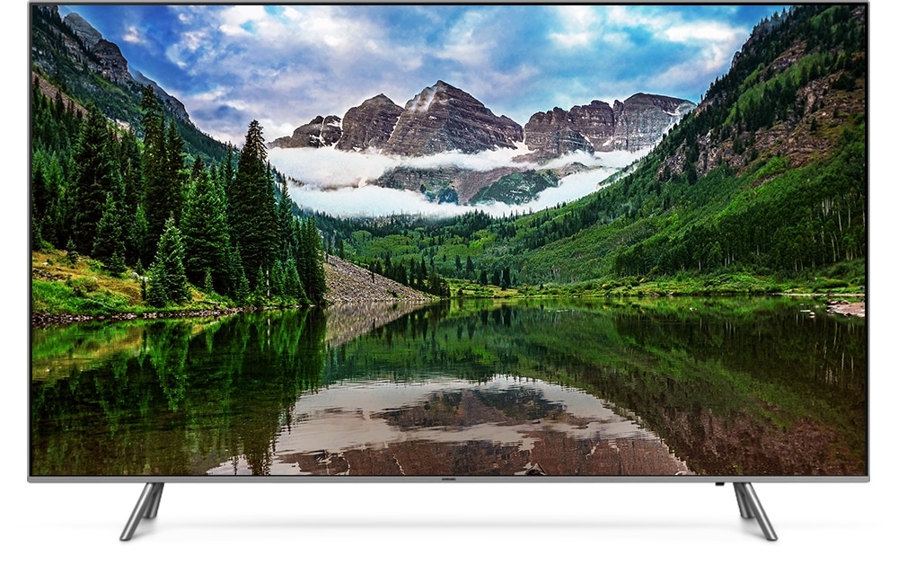 QLED TV 제품이 정면으로 놓여져 있고 화면 안에는 중앙의 호수를 산이 둘러싸고 있는 이미지가 선명하고 생생하게 보여집니다.