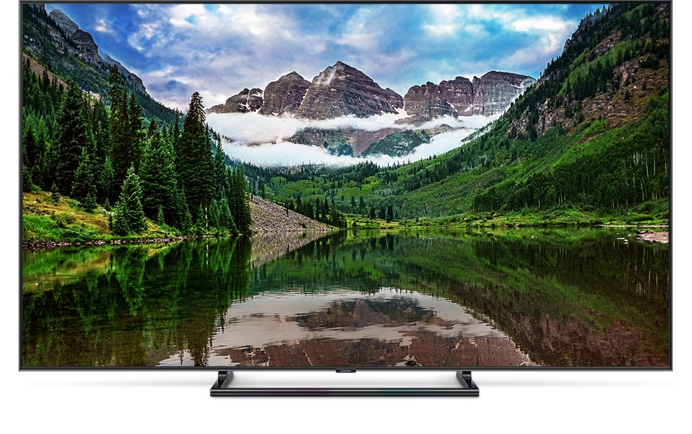 QLED TV 제품이 정면으로 놓여져 있고 화면 안에는 중앙의 호수를 산이 둘러싸고 있는 이미지가 선명하고 생생하게 보여집니다.