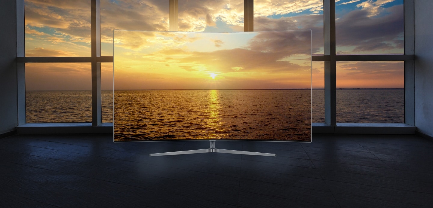 방안의 격자무늬의 창밖으로 밤의 바다가 보이고 창 앞의 커브드 스크린 티브이가 있습니다. 화면에는 밖과 같은 바다 배경이 더 또렷이 보입니다.