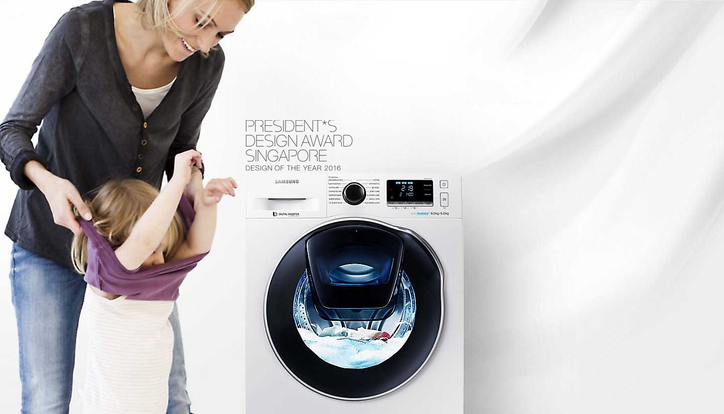 An image of a woman taking off her child's clothes next to a WW8500 washing machine which is in the middle of a cycle.