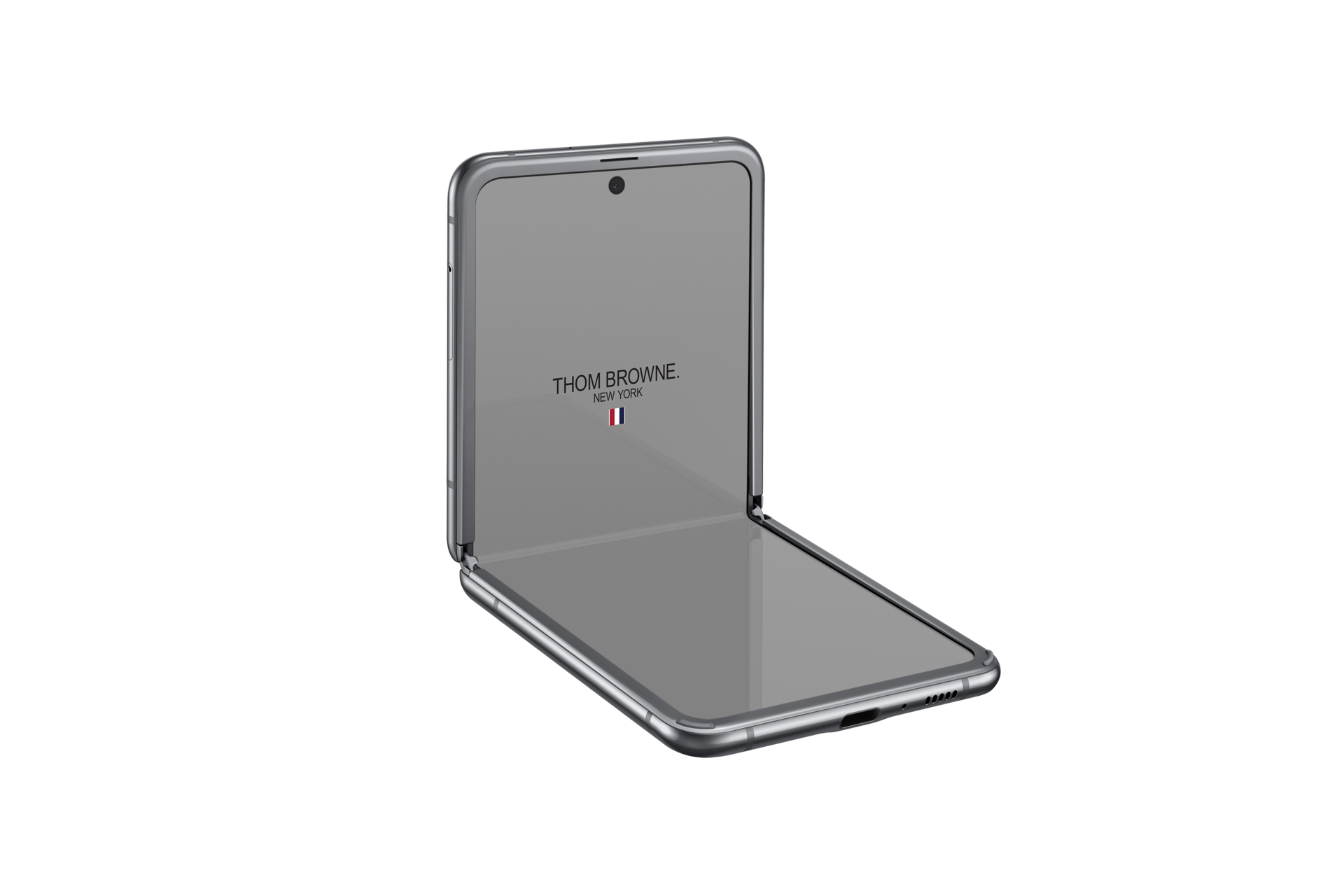 A table-top view of Samsung Galaxy Z Flip Thom Browne Singapore in Grey (SM-F700FZAZXSP) shows a Thom Browne logo onscreen
