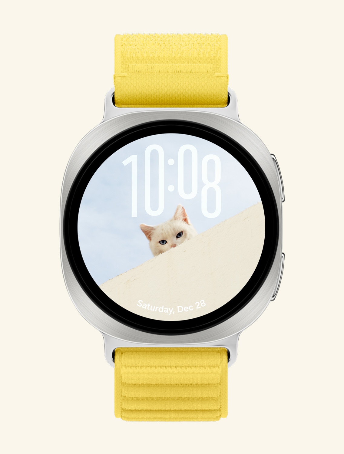 イエローのFabric Bandを装着したGalaxy Watch9の正面および斜めからのクローズアップ画像。猫の顔に重ならないよう、上部に時刻、下部の日付を配置したカスタムポートレートウォッチフェイスが表示されています。