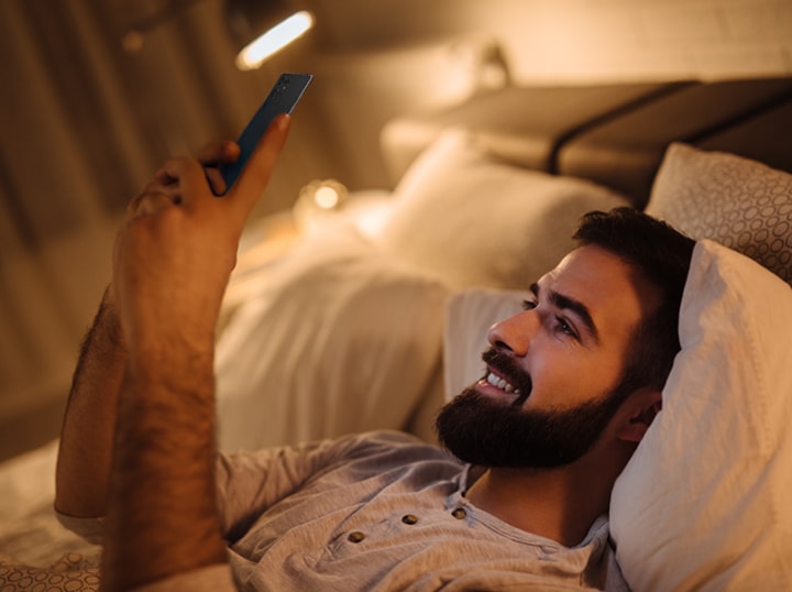 침대에 누워서 동영상을 보고 있습니다.