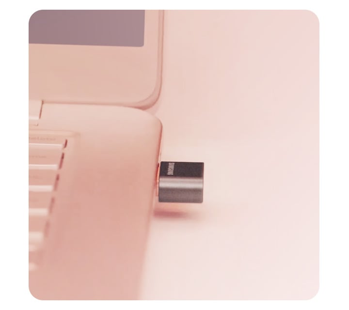 분홍색 노트북에 블랙 컬러의 FIT Plus USB 3.1 Flash Drive 제품이 연결되어있는 이미지입니다.