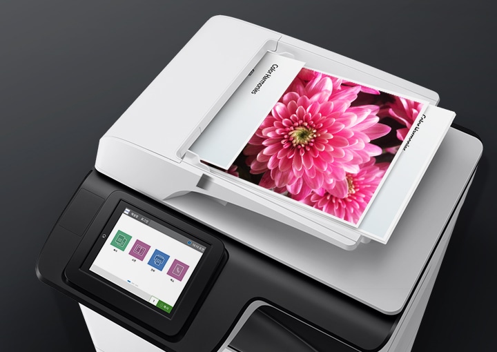 디지털 복합기 위 출력된 꽃 인쇄물이 보여집니다.