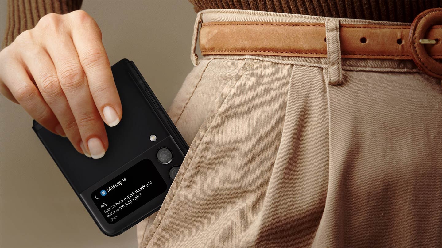 한 여성이 접은 갤럭시 Z 플립3 5G를 바지 주머니에 넣고 있습니다. 커버 화면에는 Ally의 메시지 알림이 있습니다. 
