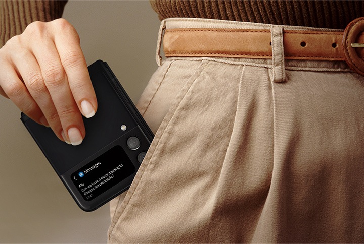 한 여성이 접은 갤럭시 Z 플립3 5G를 바지 주머니에 넣고 있습니다. 커버 화면에는 Ally의 메시지 알림이 있습니다. 