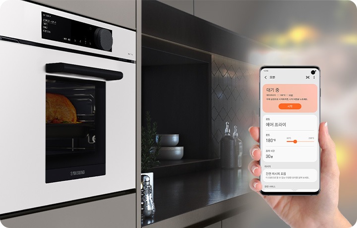 사용자가 스마트폰을 통해 전기오븐의 상태를 보고 있습니다.