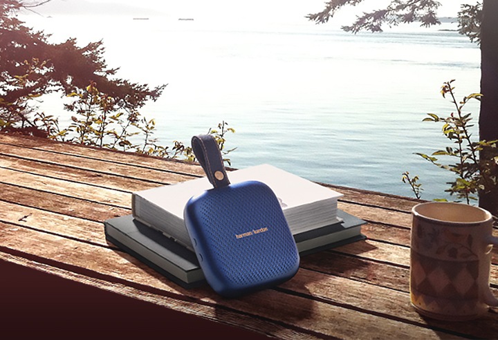 탁자위에 책과 컵, 하만카돈 neo 제품이 올려져있습니다.