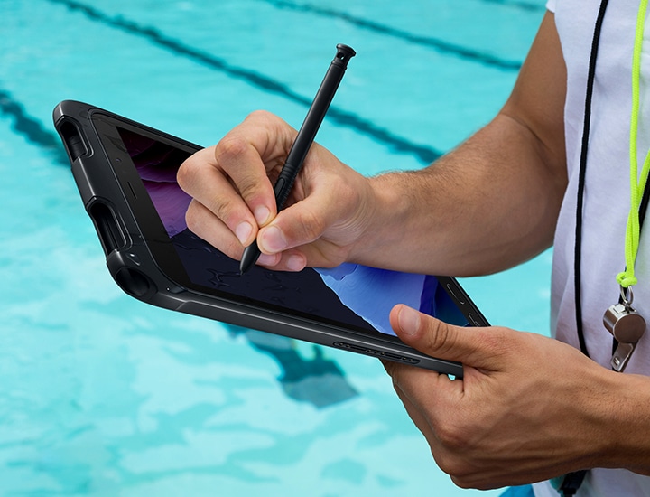 한 사람이 수영장에서 갤럭시 탭 액티브3에 S펜으로 필기를 하고 있습니다.
