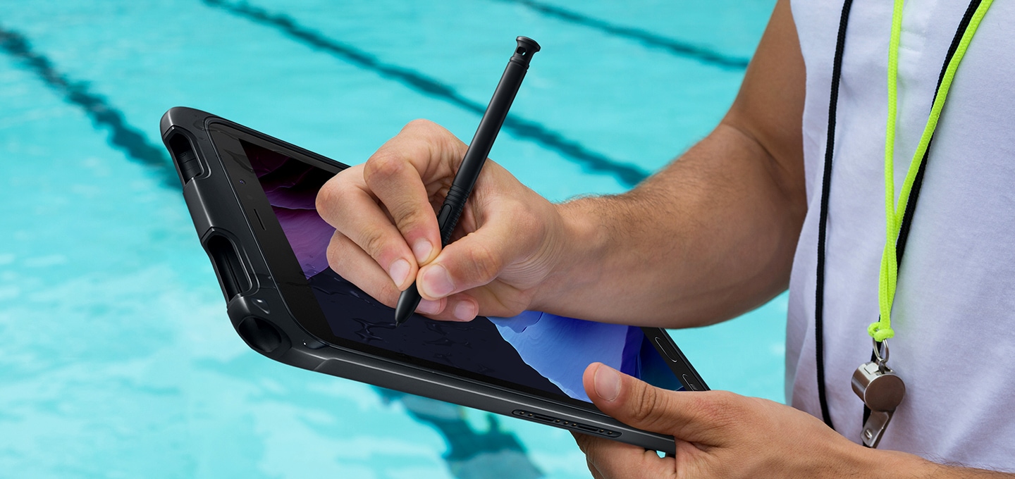 한 사람이 수영장에서 갤럭시 탭 액티브3에 S펜으로 필기를 하고 있습니다.