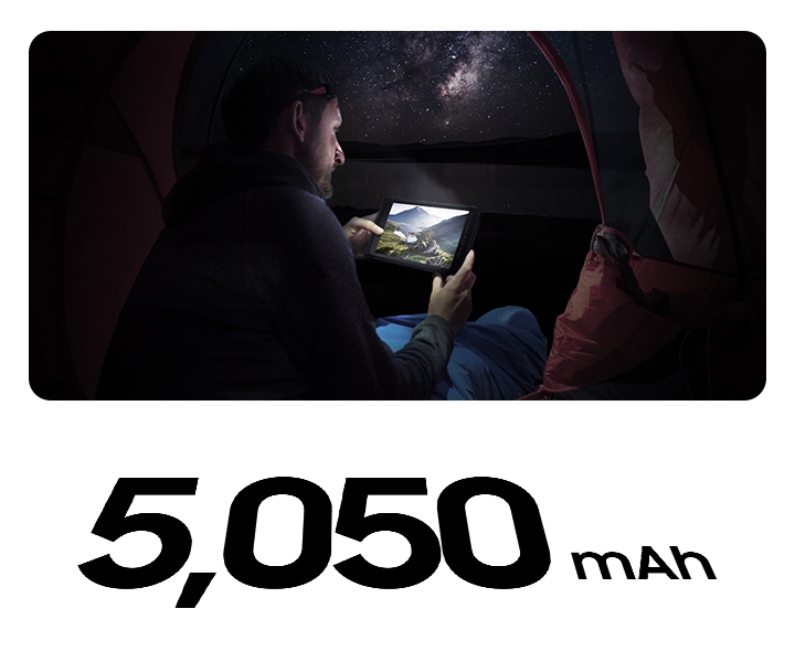 한 남성이 어두운 밤 하늘 아래에서 갤럭시 탭 액티브3로 영상을 보고 있습니다. 하단에는 5,050 mAh 배터리 용량이 표기되어있습니다.