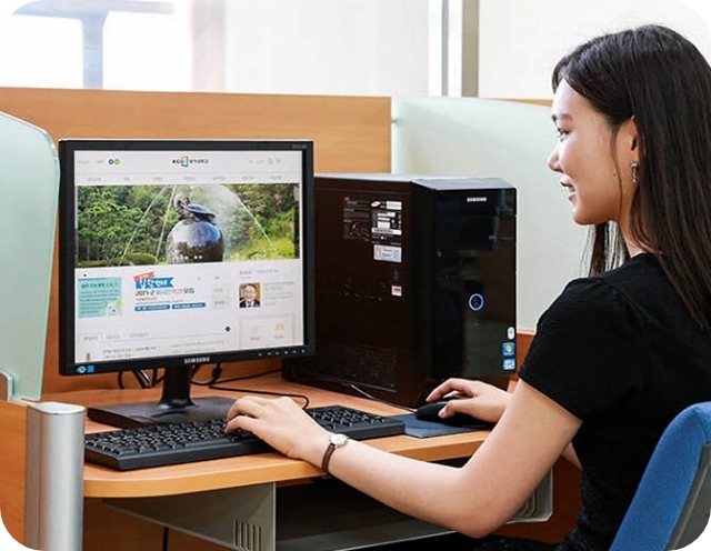 책상에서 삼성 컴퓨터로 학습하고 있는 여성의 모습