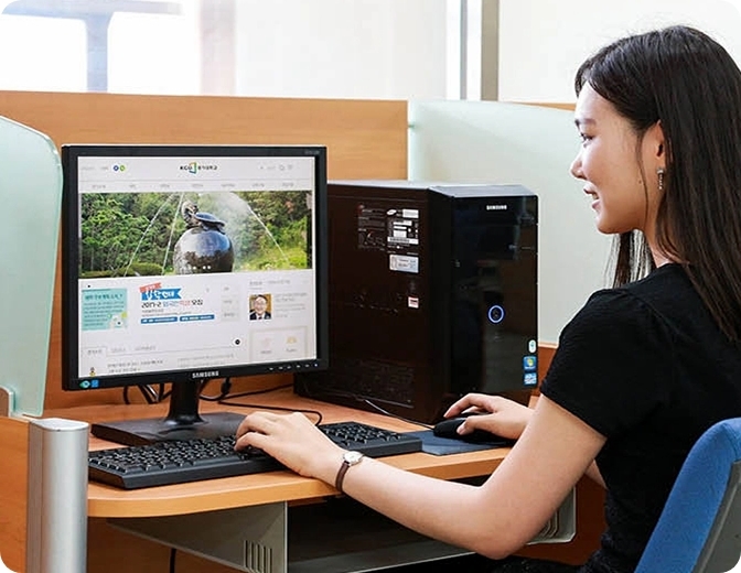책상에서 삼성 컴퓨터로 학습하고 있는 여성의 모습