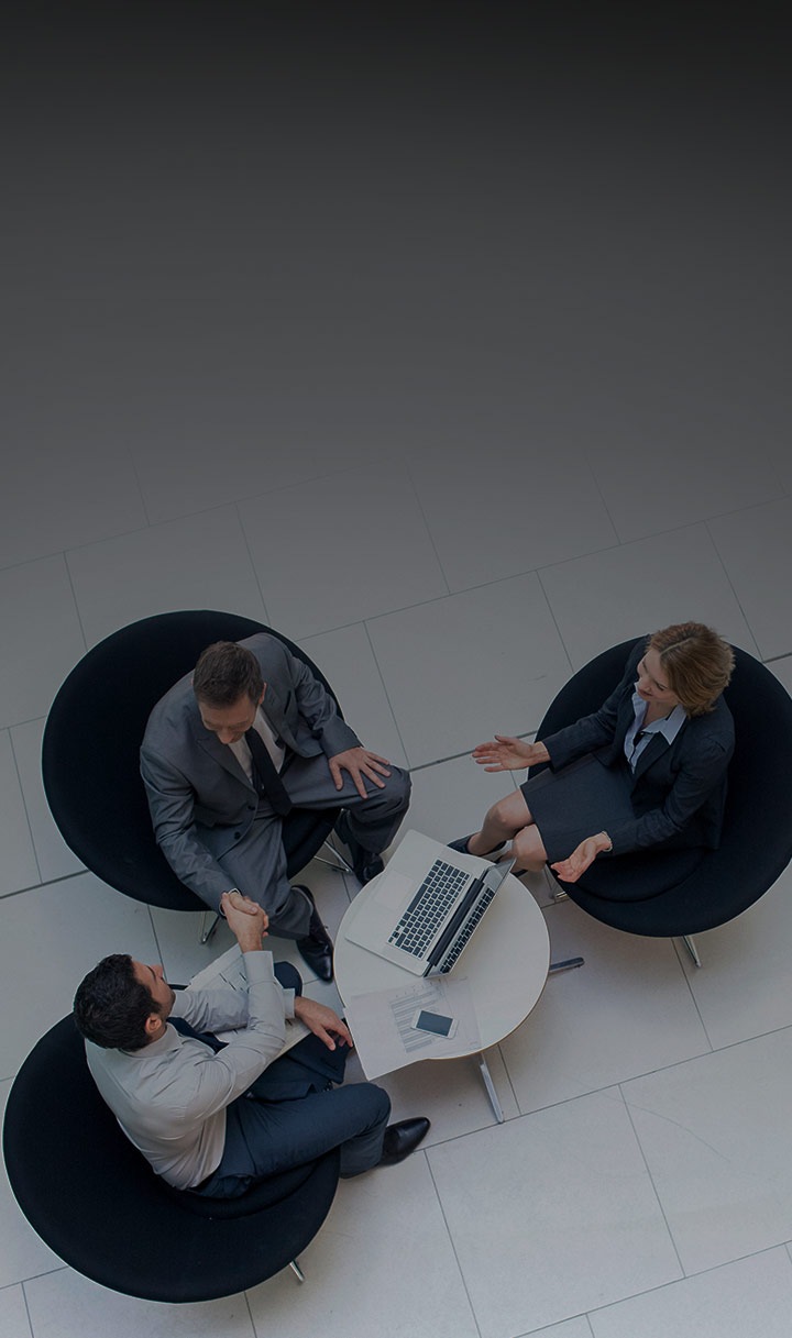 두 명의 남자와 한 명의 여자가 서류를 함께 보고 있습니다. 한 남자는 갤럭시 스마트폰을 들고 있습니다.