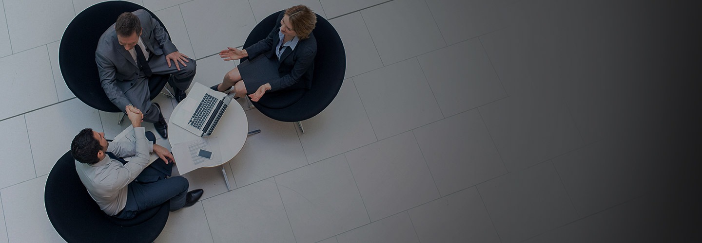 두 명의 남자와 한 명의 여자가 서류를 함께 보고 있습니다. 한 남자는 갤럭시 스마트폰을 들고 있습니다.