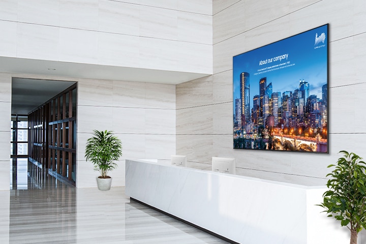 빌딩 라운지 데스크 공간이 있으며, 데스크 뒷면 벽에는 단독형 UHD E 시리즈 98인치가 설치되어 있는 모습입니다.
