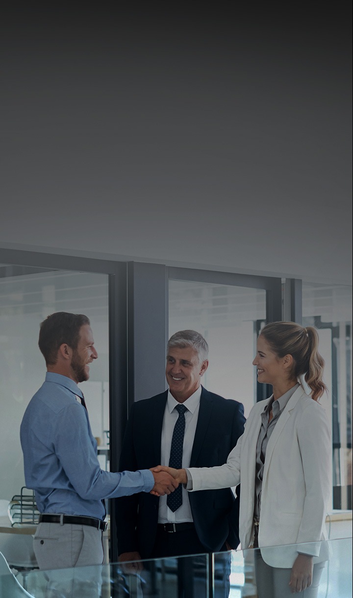 세명의 남자가 서있으며, 두명의 남자는 악수를 하고있는 모습입니다.