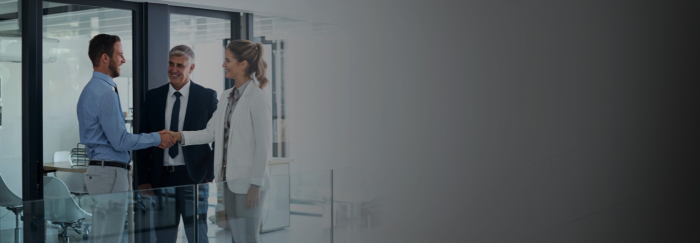 세명의 남자가 서있으며, 두명의 남자는 악수를 하고있는 모습입니다.