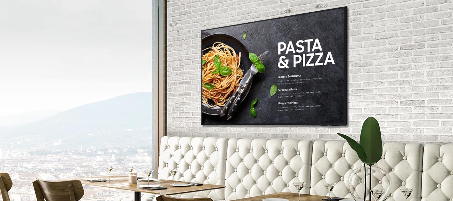 카페의 벽면에 비즈니스TV가 설치된 모습입니다. 슬림한 측면이 보이며, 고객에게 불편함을 주지 않는 두께와 세련된 디자인을 표현하고 있습니다.