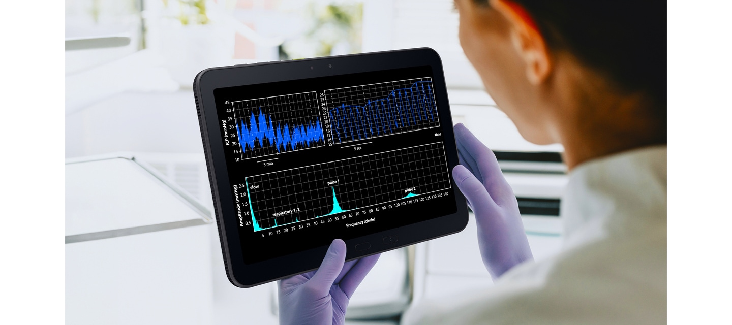 실험실 가운과 장갑을 착용한 한 사람이 갤럭시 탭 액티브5 프로를 들고 있습니다. 다양한 그래프가 표시되어 장갑을 낀 상태에서도 기기가 원활하게 작동함을 알려줍니다.