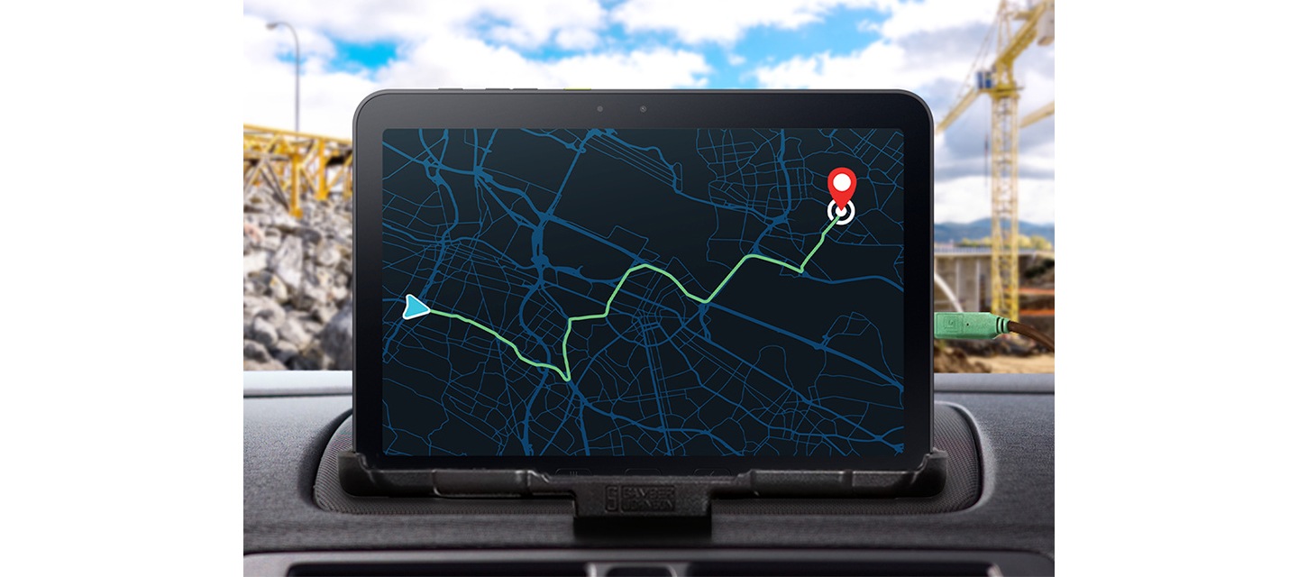 갤럭시 탭 액티브5 프로를 차량 내부에 배치한 모습입니다. 화면에는 목적지까지 경로 안내가 포함된 지도가 표시됩니다. 차량 외부에는 공사 현장의 모습이 있으며 배터리를 사용하지 않고 외부 전원으로 기기를 직접 작동시키는 방식임을 알려줍니다.