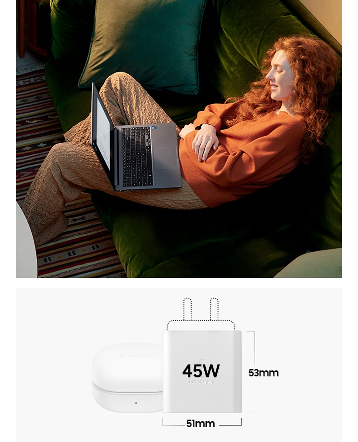 젊은 여성이 소파에 앉아 그레이 컬러의 갤럭시 북4로 콘텐츠를 감상하고 있습니다. 이미지 우측에는 기본 제공되는 노트북 충전기가 갤럭시 버즈2 프로 케이스와 나란히 놓여 있어 버즈 케이스 만큼 작은 사이즈를 강조하고 있습니다. 충전기 본체 크기는 가로 51 mm, 세로 53 mm입니다.