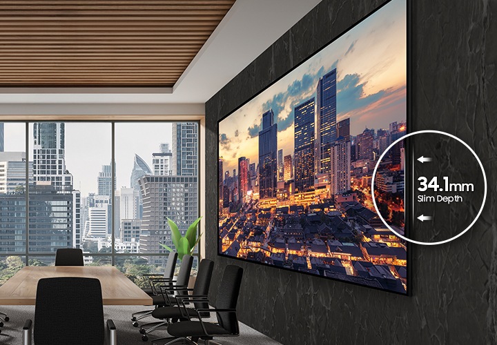 대형 회의실 벽면에 설치된 단독형 사이니지의 모습이 보입니다. 화면에는 도시의 야경이 디스플레이 되고 있으며, 측면 프레임 부분의 일부분을 확대하여 34.1mm Slim Design 이라는 표기가 있습니다.