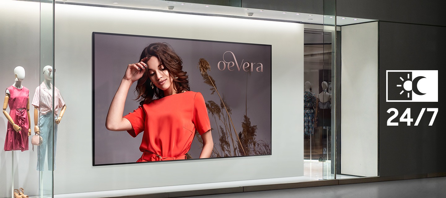 폐점 상태의 야간 대형 의류매장 쇼윈도 벽면에 설치되어 매장 홍보이미지가 송출중인 단독형 사이니지의 모습이 보이며, 그 옆으로 해와 달을 의미하는 아이콘과 함께 24/7 이라는 표기로 낮과 밤 상관없이 24시간 화면 송출이 가능함을 표현하고 있습니다.