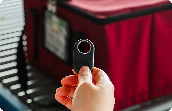 갤럭시 스마트태그를 들고 택배 상품을 태그중인 손 이미지