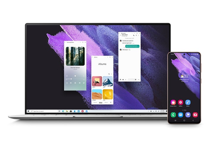 노트북과 갤럭시 S21+ 5G가 전면이 보이도록 나란히 놓여 있습니다. 노트북 화면에는 스마트폰 앱의 갤러리, 메시지, 삼성 뮤직 앱이 표시되어 있습니다. 이는 갤럭시 S21+ 5G와 노트북의 동기화된 모습을 보여주는 장면입니다.