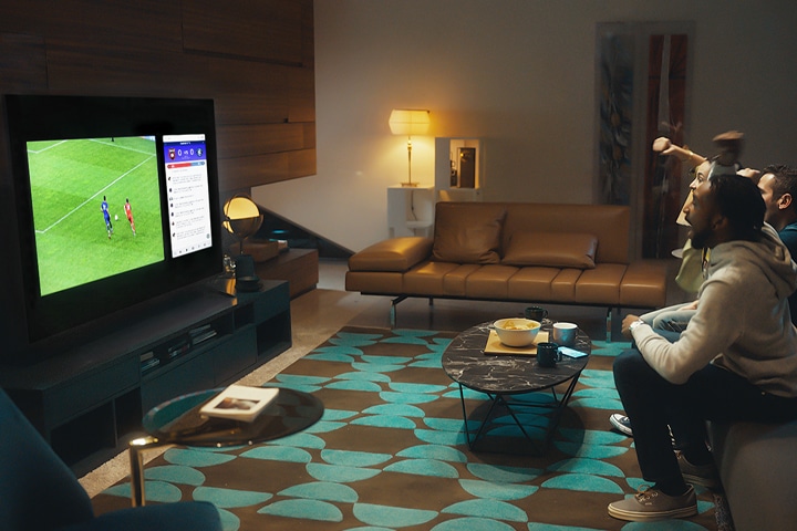 사용자가 TV 를 보고 TV 온스크린에는 축구화면이 나오고 있습니다.