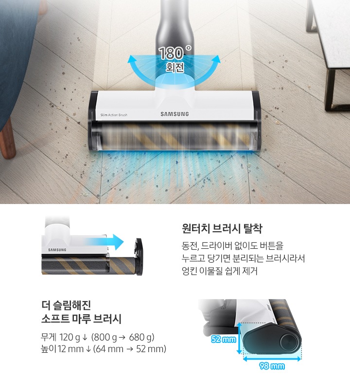 헤링본 패턴의 마루가 보이며 왼쪽에는 소파의 하단부, 오른쪽에는 작은 테이블의 하단부가 보입니다. 이미지 중앙으로 슬림 소프트 마루 브러시로 바닥을 청소하는 모습입니다.