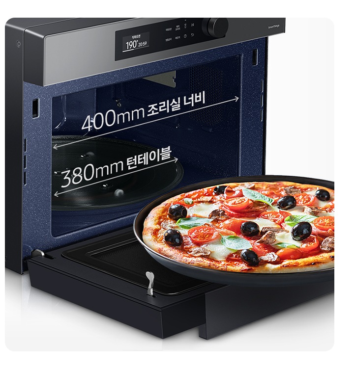 Bespoke 직화오븐 35L 글램 차콜이 45도 각도로 앞면이 보이게 위치해 있으며, 도어는 완전히 열려 있습니다. 열려진 도어 위로는 피자가 들어있는 팬이 있습니다. 오븐 입구 윗쪽으로는 조리실 가로 전체를 화살표로 표시 후 400mm 조리실 너부 라고 기재되어 있으며, 그 아래로는 턴테이블 가로 전체를 화살표로 표시 후 380mm 턴테이블 이라고 기재되어 있습니다.