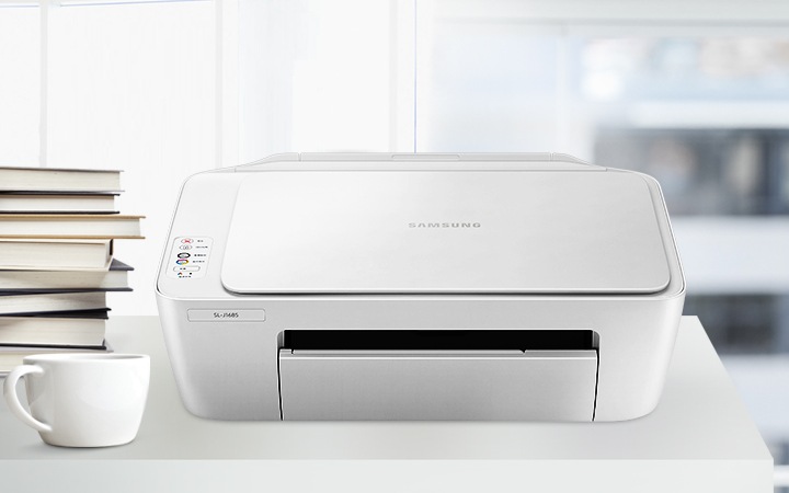 밖에 건물이 흐리게 보이는 창문이 이미지 오른쪽에 있으면 이미지 중간에는 하얀색 책상 위에 올려져 제품의 정면 이미지가 있고 이미지 왼쪽에는 컵과 책이 쌓여있는 이미지가 있습니다.