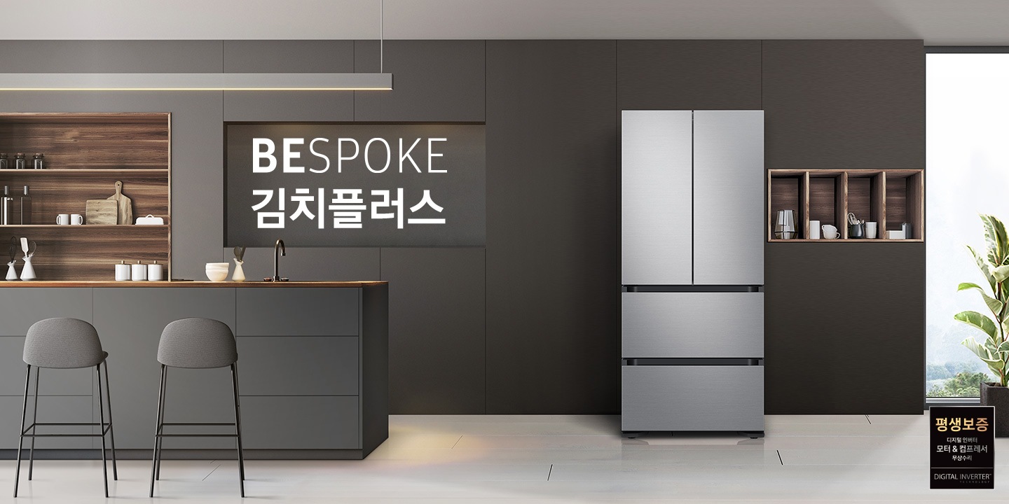 김치냉장고가 정면으로 세워져 있는 주방 모습입니다. 앞쪽으로 조리대가 보이고 오른쪽 뒤 큰 창으로 푸르른 나무들이 보입니다.