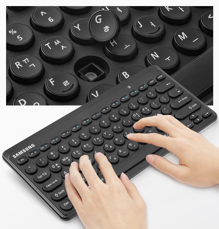 키 캡 내부가 확대되어 보이고 하단에는 키보드를 사용중인 손이 보입니다.