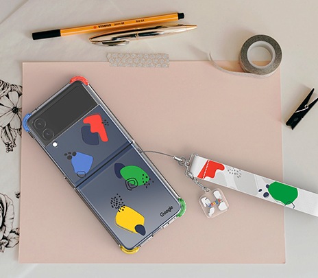 스트랩이 달린 클리어 커버가 장착된 갤럭시 Z 플립3 5G가 바닥에 놓여져 뒷면이 보이고 있습니다.