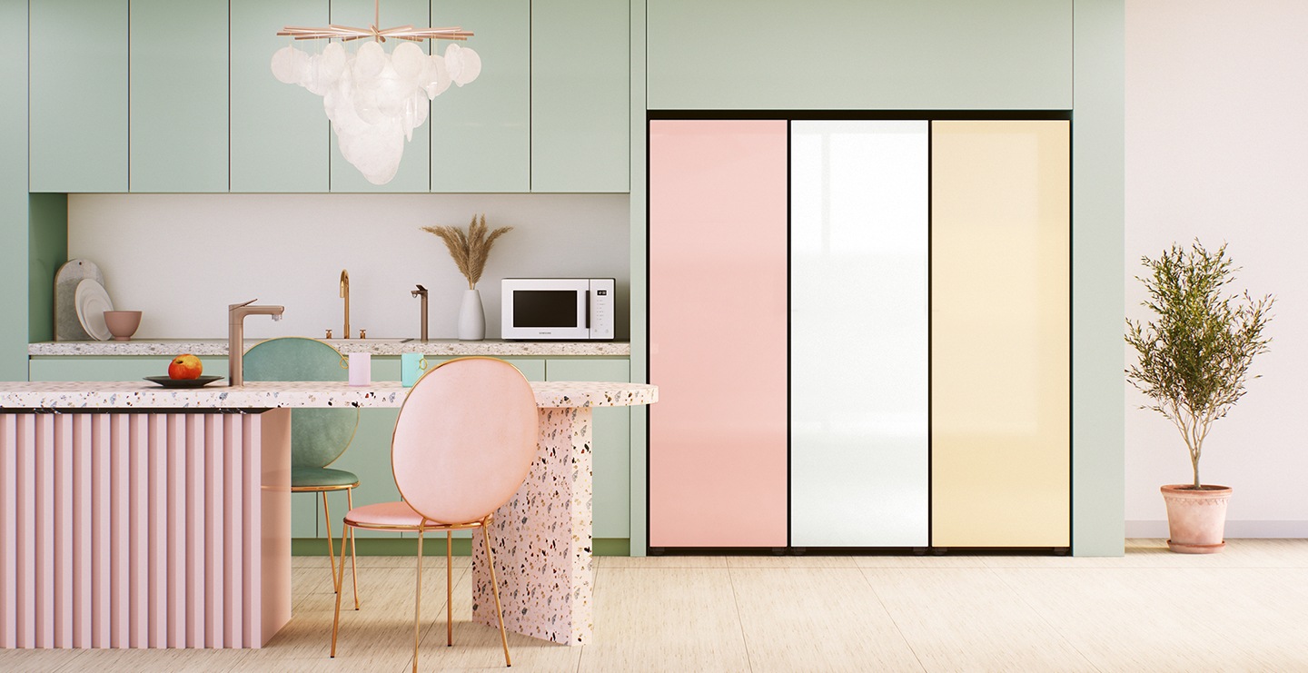 그린과 핑크톤으로 이루어진 인테리어 주방과 그린톤으로 이루어진 벽면에 1도어 김치냉장고 3개가 나란히 나열 되어있습니다. 제품 왼쪽엔 그린톤의 싱크대, 상하부장이 있으며 하부장 위에는 전자레인지 화이트 색상이 놓여있습니다. 상하부장 앞에는 핑크톤의 2인 식탁이 있고 식탁 위에는 정수기가 설치 되어있습니다. 식탁 중심으로 앞 뒤에 핑크색, 그린색의 의자가 놓여있습니다.