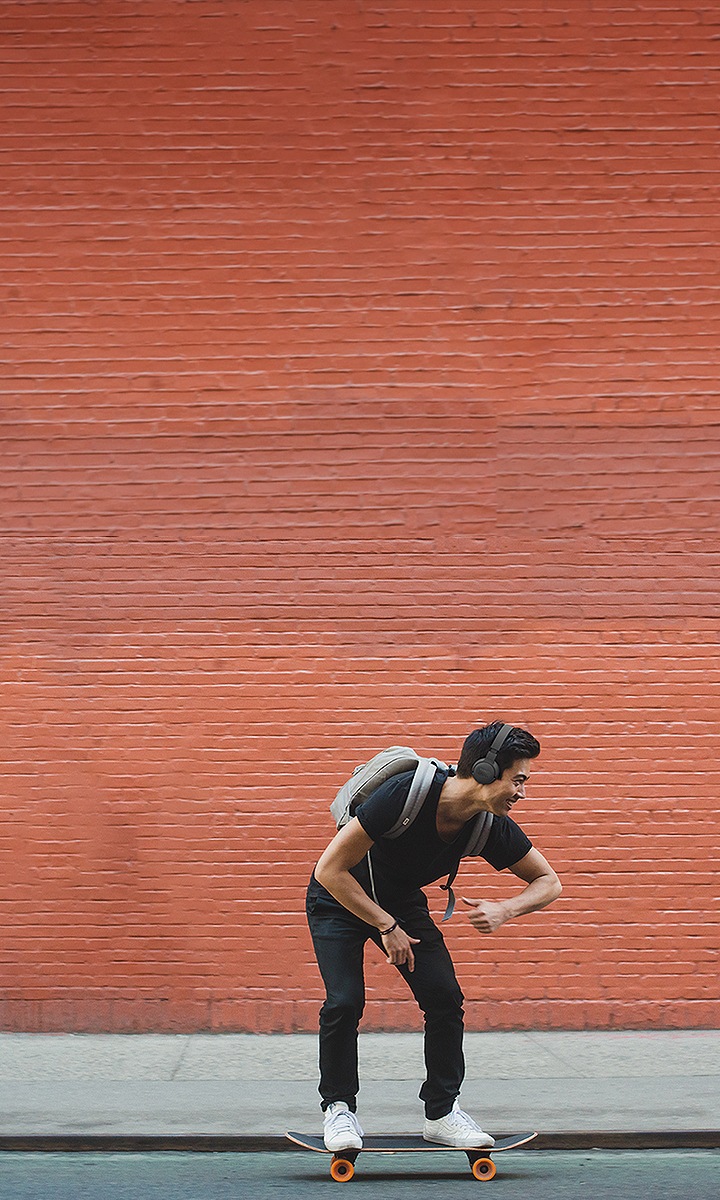 남성 사용자가 JBL TUNE 660NC 제품을 착용하고 보드를 타고 있습니다. 