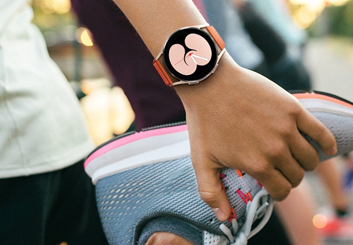 스트랩을 찬 손으로 운동화 잡고 있는 사진