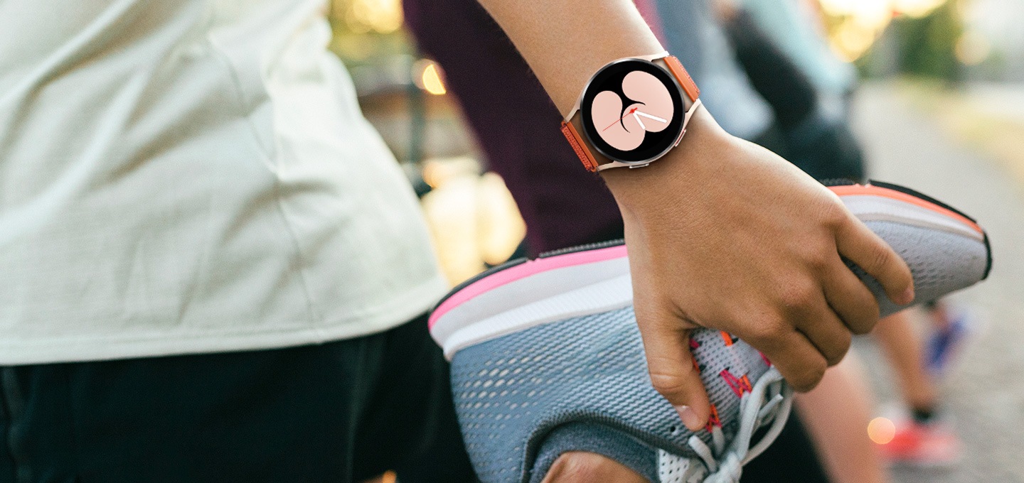 스트랩을 찬 손으로 운동화 잡고 있는 사진