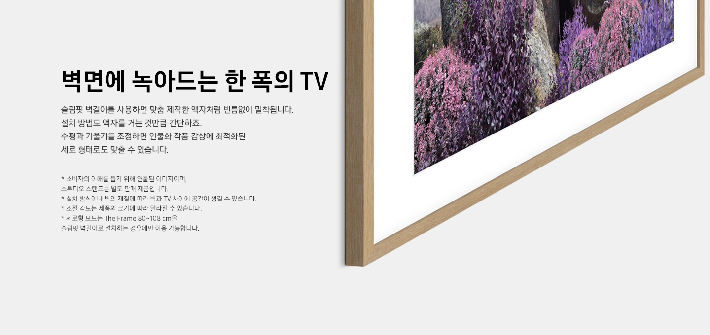 벽면에 tv 가 설치되어 있습니다. 화면에는 보라색 꽃들이 보입니다.