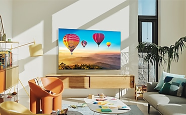 벽걸이 TV가 설치되어 있고 화면에는 열기구 풍경이 보입니다.