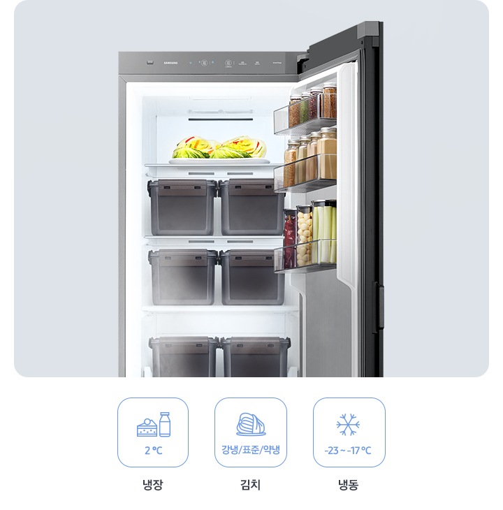 김치냉장고 문이 열려있으며 안에 칸마다 음식이 놓여져 있습니다. 이미지 하단에는 냉장, 김치, 냉동에 관련된 문구와 해당 되는 아이콘이 그려져있으며 냉장은 2°C, 김치는 강냉/표준/약냉, 냉동은 -23~-17°C 문구가 아이콘 아래에 적혀 있습니다.